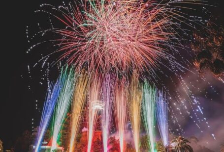 Roman Carnival - Long exposure of vibrant sparkling fireworks and bright multi colored Roman candles over palms and pavement at night