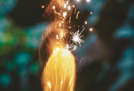 Roman Designers - Bright firework candle burning on blurred background in evening