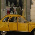 Shopping Districts - Yellow Vintage Car on a Street